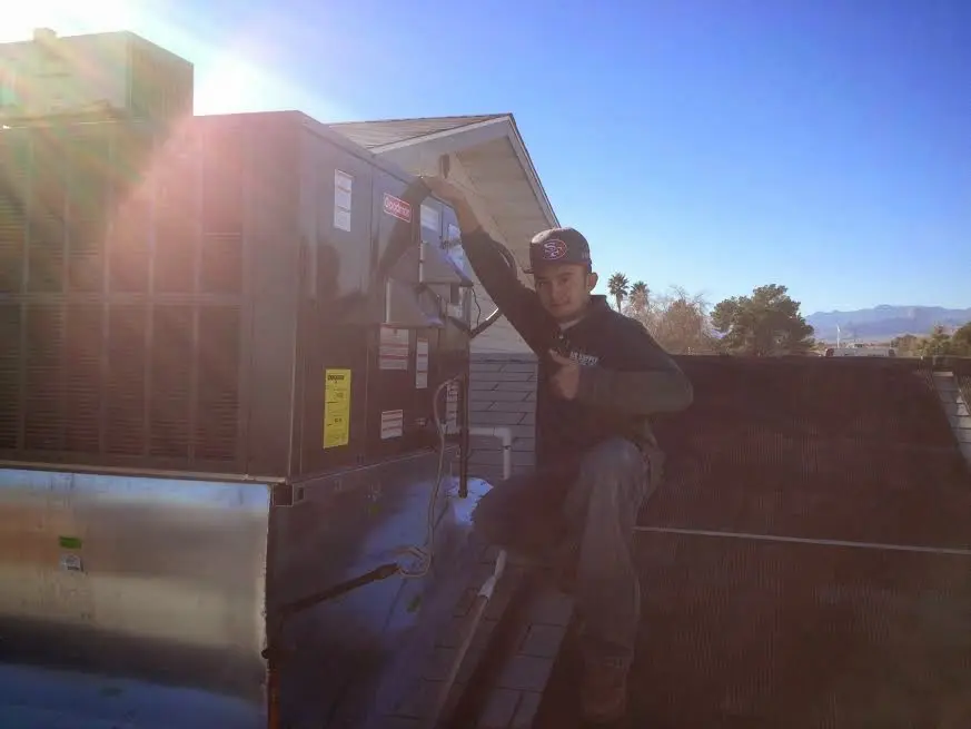 HVAC technician performing AC Tune-Up on a rooftop unit in Fallbrook